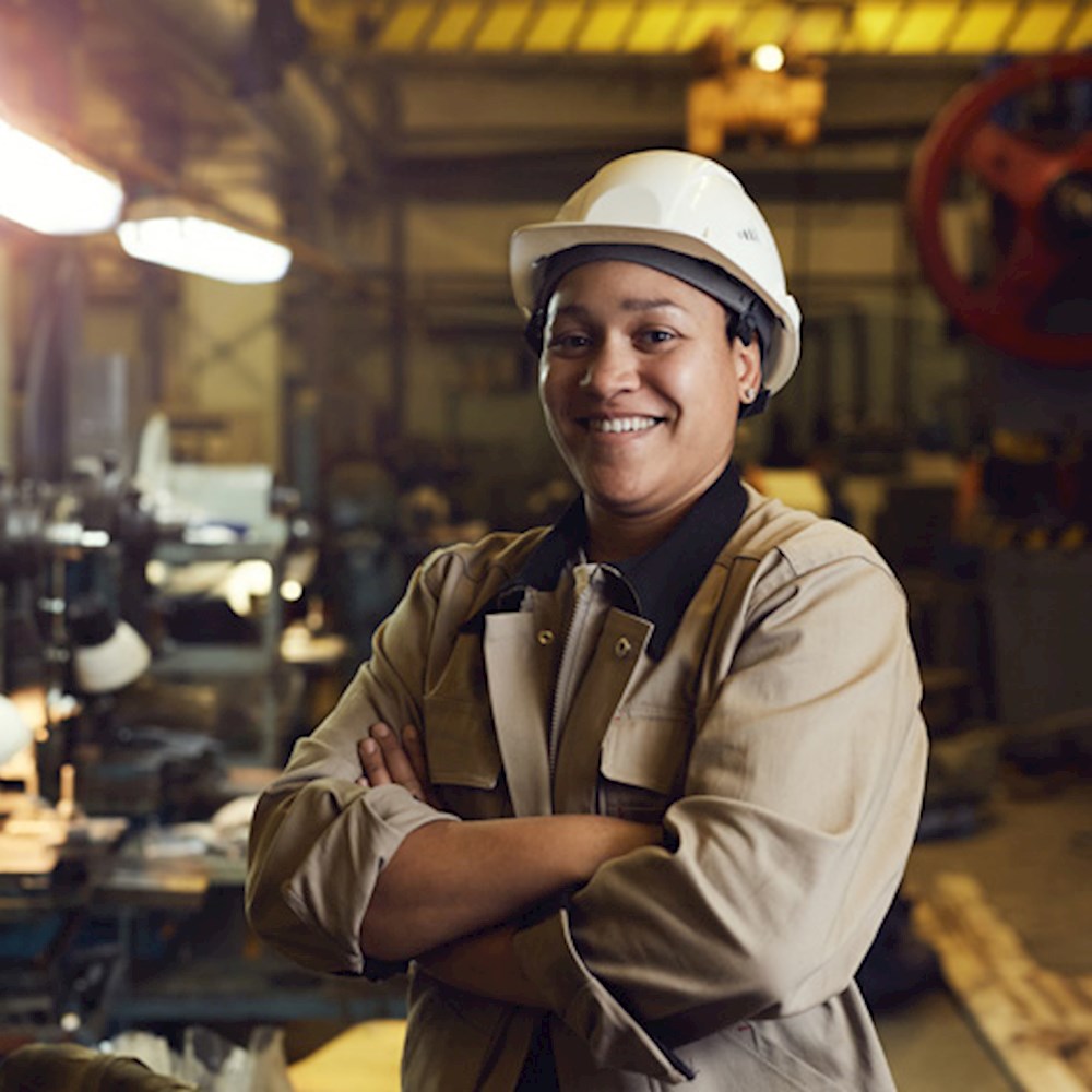 Industrial worker smiling in factory, showing DP World’s cultural alignment and inclusive workforce in logistics.