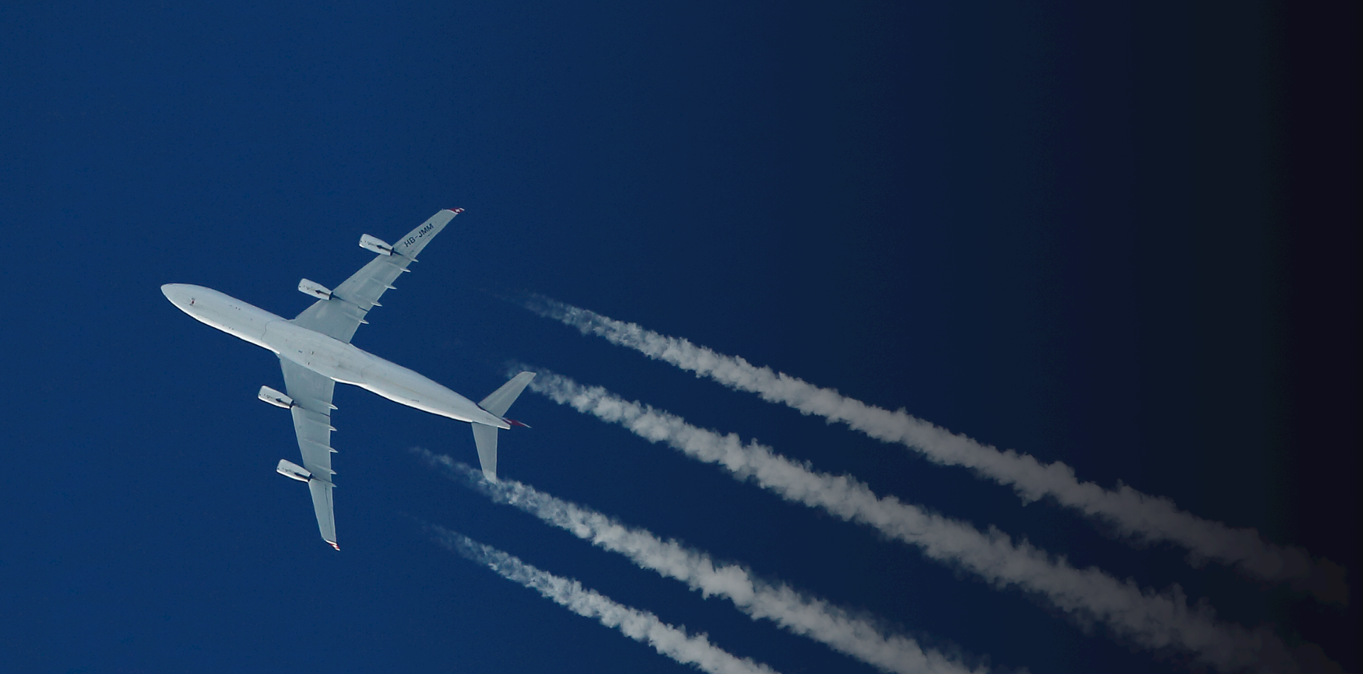 High-altitude cargo airplane flying across a clear sky with contrails, symbolizing fast and reliable global air freight logistics and time-critical cargo transport solutions.
